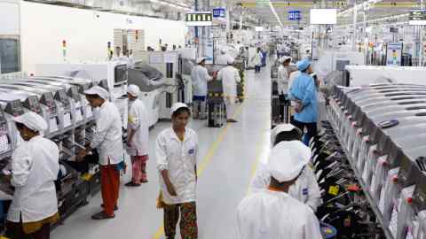 Employees on an assembly line in the mobile phone plant of Rising Stars Mobile India, a unit of Foxconn, in Sriperumbudur, India