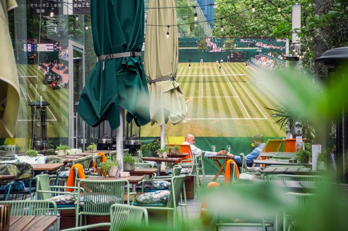 The Refinery Bankside’s terrace, with an Aperol counter and wooden tables shaded by orange parasols