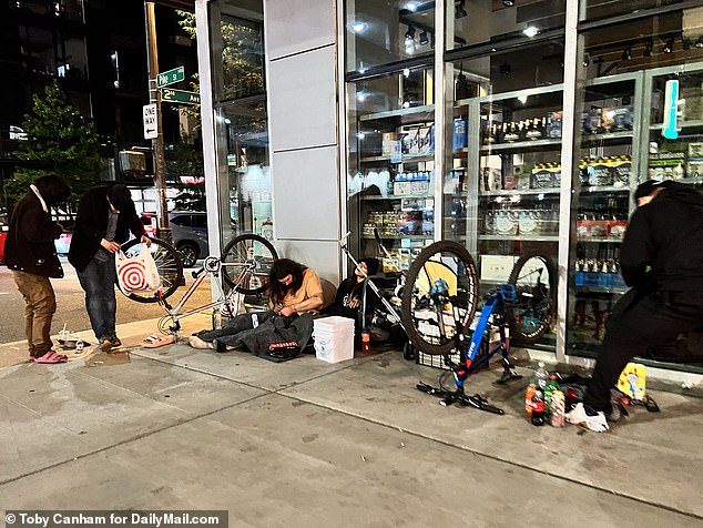 One man can be seen here openly using a hypodermic needle as he lays on the sidewalk