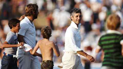 Young boys surround a smiling Mike Brearley on a cricket pitch