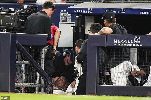 A camera operator receives medical attention after getting hit in the head by a stray throw