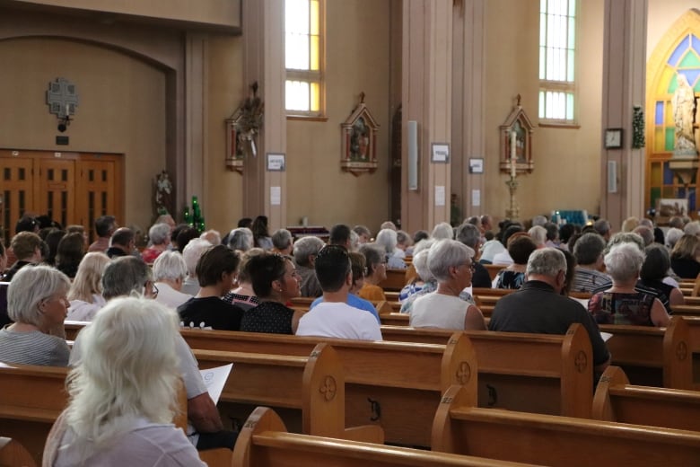 People sit in pews at a church