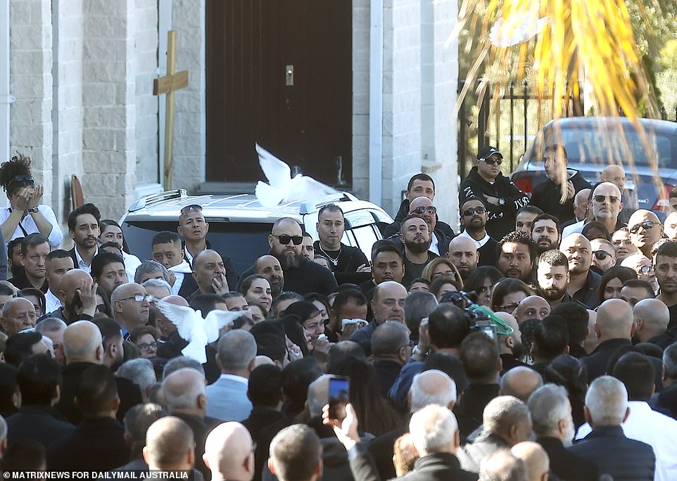 Crying women reached out to touch Mr Brikha's coffin as it was slowly walked down the aisle of the church to an awaiting hearse