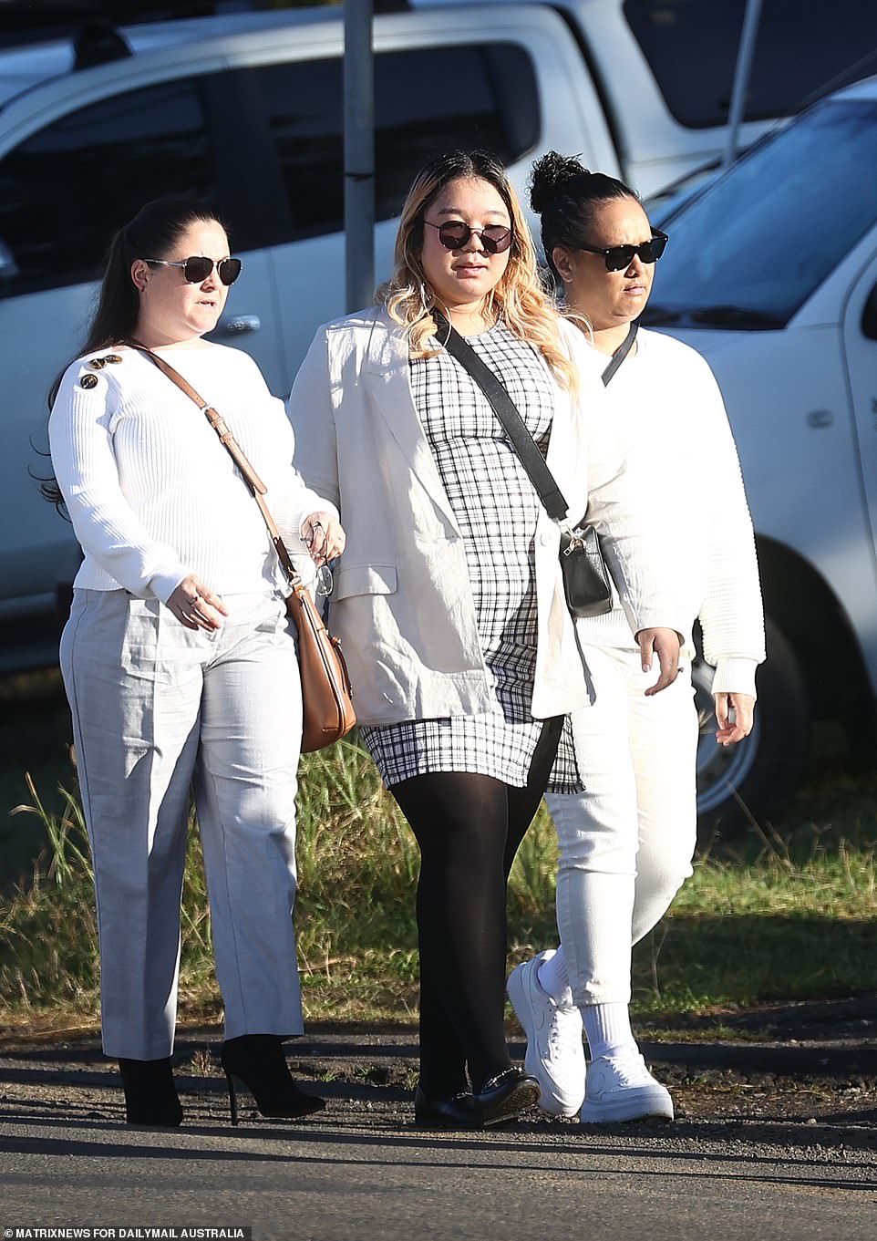 Mr Brikha's friends dressed in white walk towards the church ahead of the service