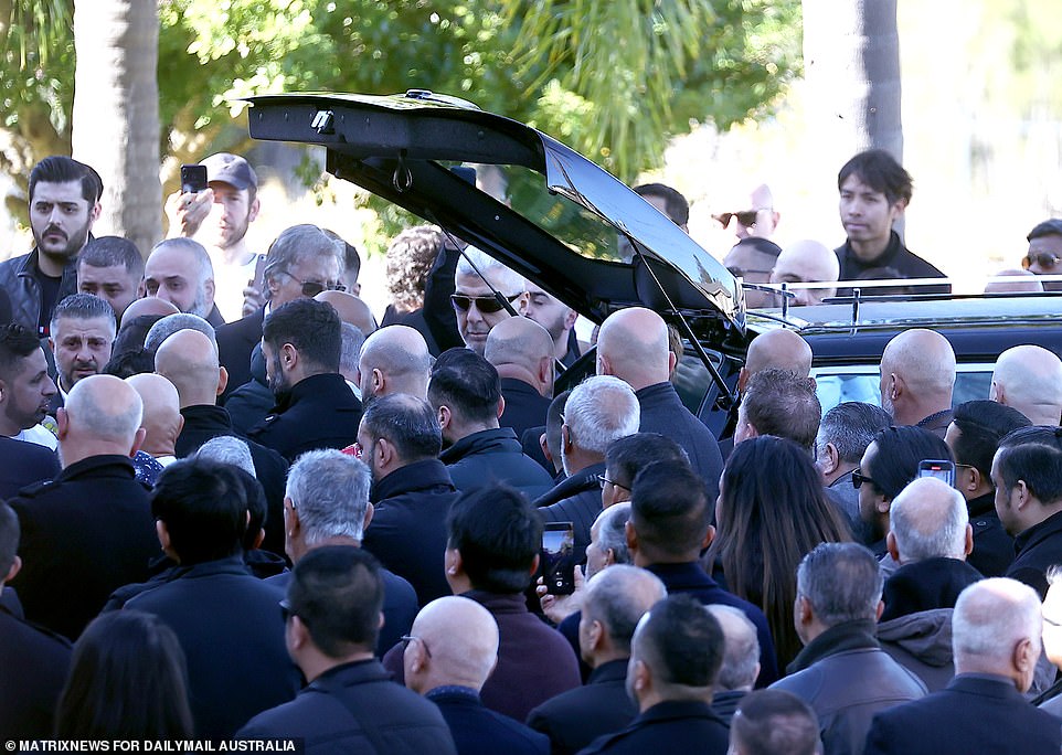 Many friends and loved ones pulled out their phones to film as Mr Brikha's coffin was placed into the hearse