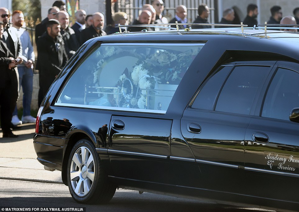 The 37-year-old's white casket was decorated with bouquets filled with white, red and blue flowers