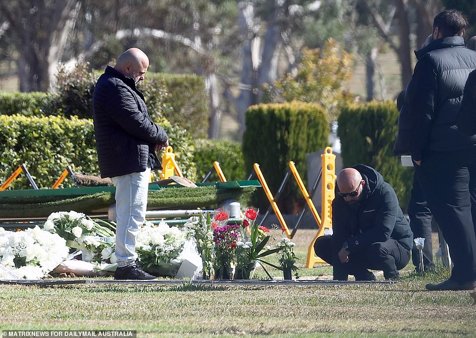 One man, overwhelmed with grief, lent down over the grave as everyone prepared to leave the cemetery