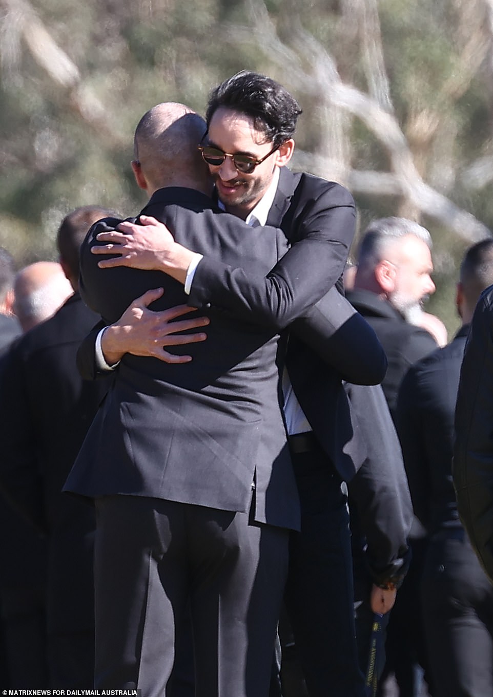 Two men hugged as emotional scenes unfolded as Mr Brikha was laid to rest