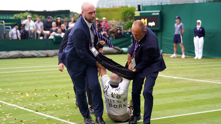 A Just Stop Oil protester is carried off court 18 after throwing confetti on to the grass during Katie Boulter&#39;s first-round match against Daria Saville on day three of the 2023 Wimbledon Championships at the All England Lawn Tennis and Croquet Club in Wimbledon.…