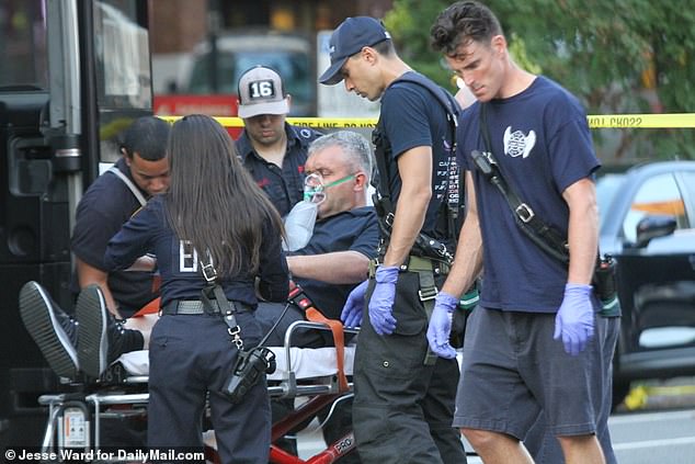 A man receives medical assistance at the site of the bus crash on 1st Ave and E. 23rd Street