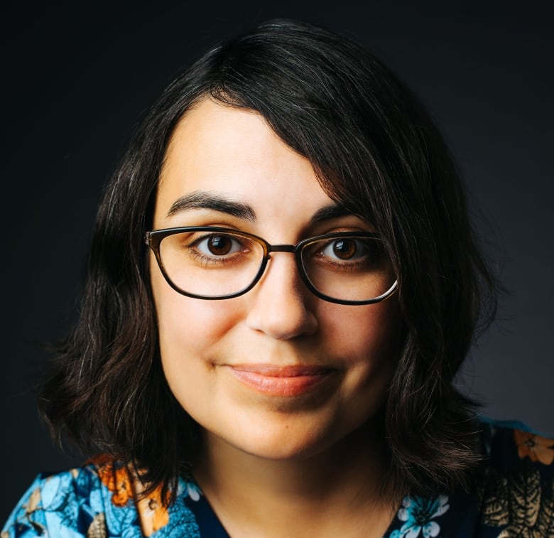 A close-up of a woman in glasses.