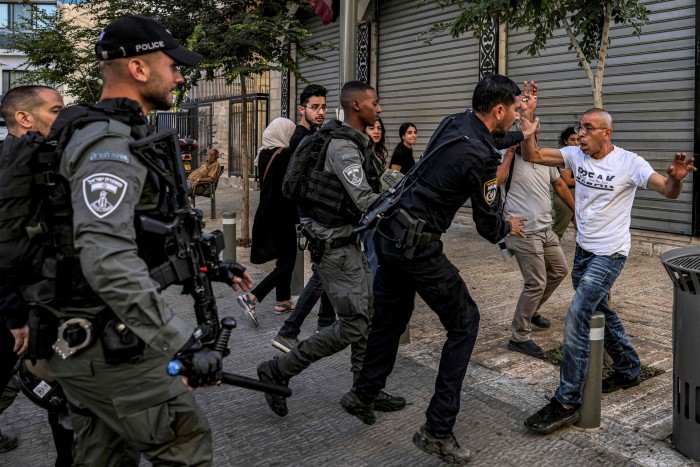 An Israeli policeman and a Palestinian scuffle during a protest against the Israeli military operation in Jenin 