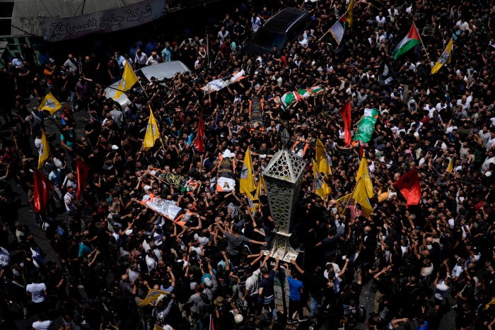 Mourners carry the bodies of Palestinian men, some draped in the flags of the Islamic Jihad militant group and Hamas, during their funeral, in the Jenin refugee camp