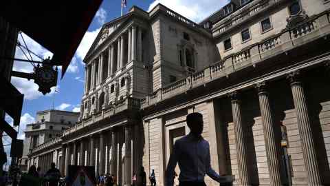 Pedestrians pass the Bank of England in London. The UK requires a multiyear plan, the redistribution of economic burdens and a decrease in inflation