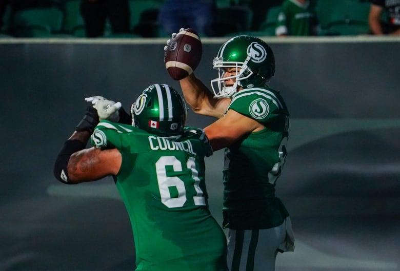 Saskatchewan Roughriders receiver Mitchell Picton celebrates by jumping up in the air with offensive lineman Brandon Council after scoring against the Edmonton Elks during the second half of CFL football action in Regina, on Thursday, July 6, 2023. 