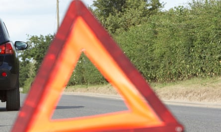 Warning triangle behind a car in a country lane