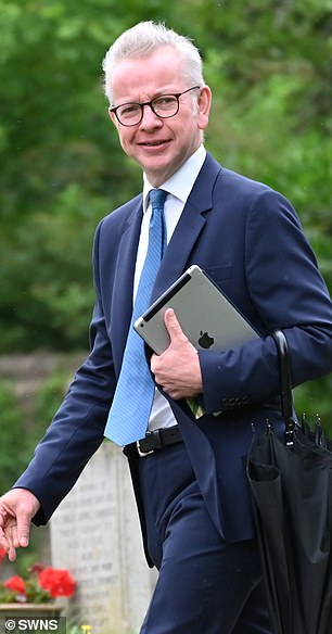 Michael Gove walks into the 14th century church carrying an iPad