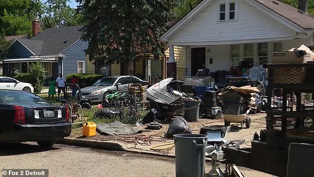 Boxes of rubbish, parts of a fence, cables and rubbish bins can be seen covering his front yard in this picture