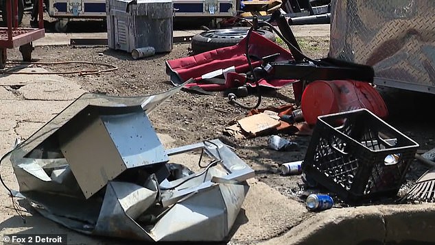 Cans of Bud Light, an old tire and what looks to be scrapped metal can be seen strewn across the yard