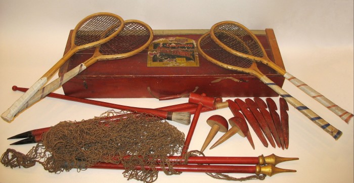 One of the 1874 tennis kits created and marketed by Major Walter Wingfield - a red-painted wooden box with rackets and a net lying on and around it