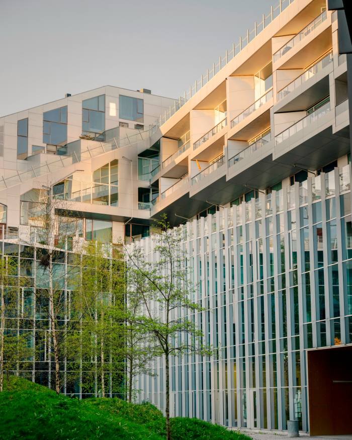 An external shot of two of 8Tallet’s buildings, with glass and orange-metal facades