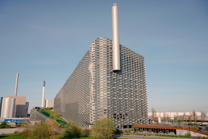 The aluminium checkered facade of CopenHill, with a metallic chimney rising above it from one side 