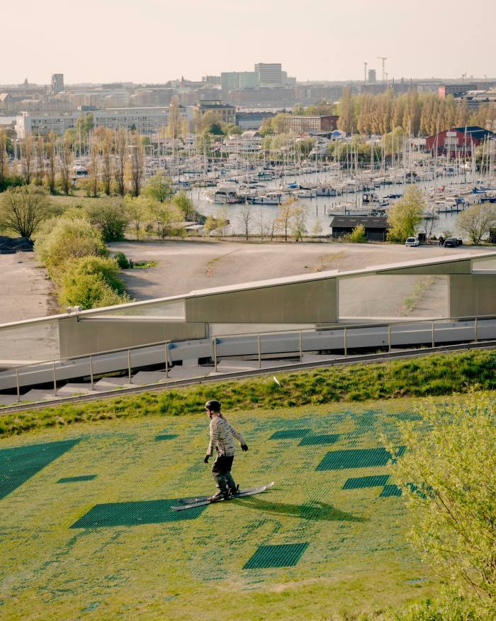 A female skier descending the artificial ski slope at CopenHill