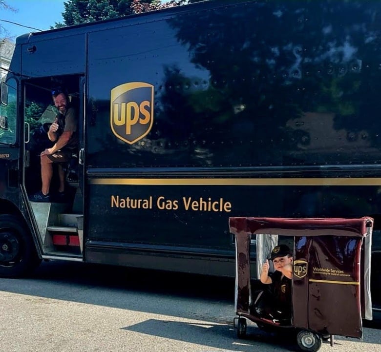 Andrew Moran, 43, gives the thumbs up from his UPS truck, alongside mini-me, 3-year-old Malcolm Oshalla of St. Thomas, Ont., in the truck his nana made him.