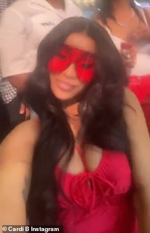 Stunning: The star changed into a plunging red dress with halter straps to accentuate her ample assets and she also rocked a pair of oversized wraparound red shades