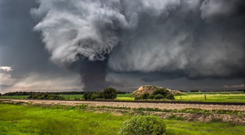 A cloud hovers over farmland. 