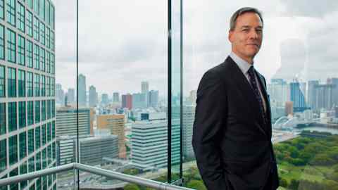 Eric Johnson stands at the window of his office in Tokyo