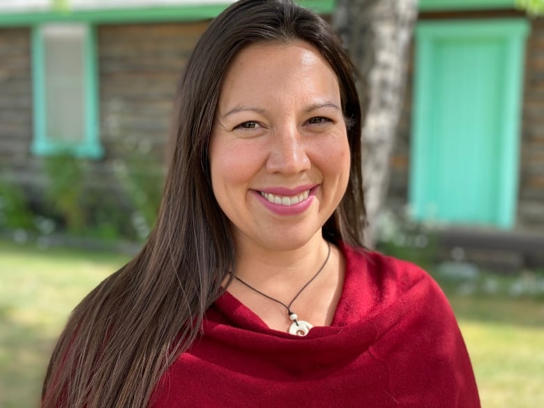 A portrait of a smiling woman with long dark hair.