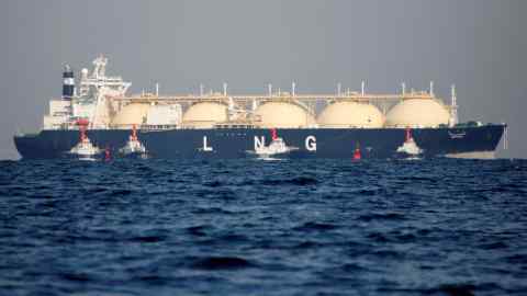 A liquefied natural gas tanker is tugged towards a thermal power station