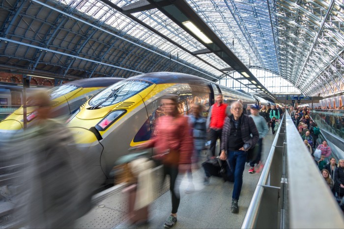 Passengers walk past a Eurostar train at London St Pancras International train station, London