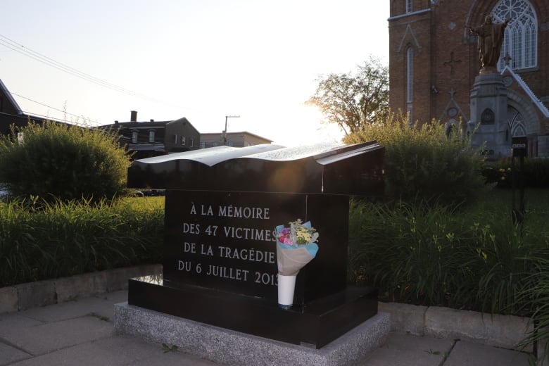 A memorial in the shape of a book. The plaque reads a memorial for the 47 victimes of the tragedy on July 6. 