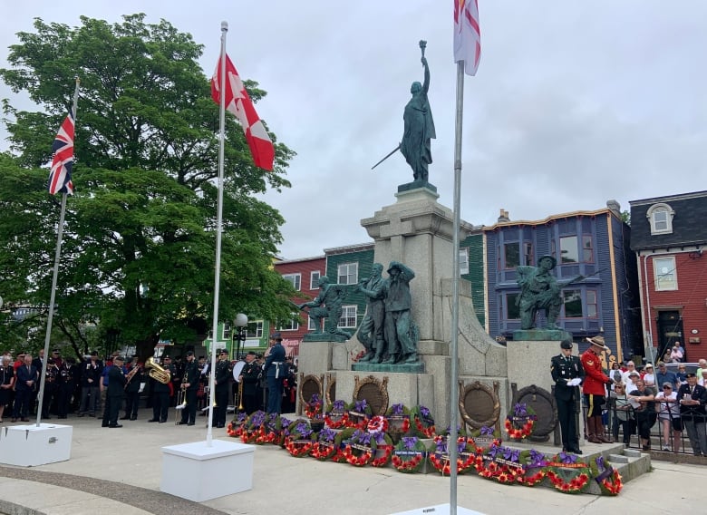 A military marching band stands aside the National War Memorial in downtown St. John's. Dozens of wreaths lay at the base of the monument.