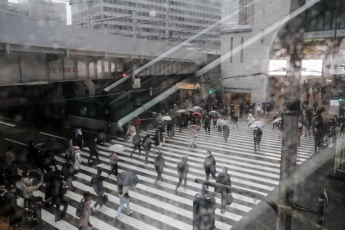 Pedestrians cross a road in Osaka, Japan, on Monday, Feb. 13, 2023. 