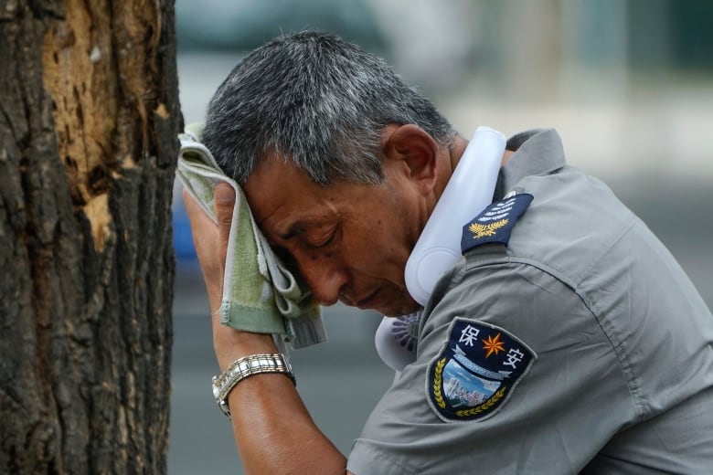 A man wipes his brow on a hot day in Beijing, China.