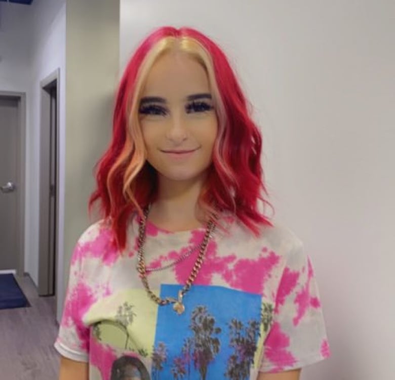 A young girl with red hair and a Tupac shirt. 