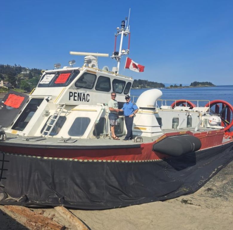 Gino LeBlanc and a Coast Guard official shake hands on board the hovercraft.