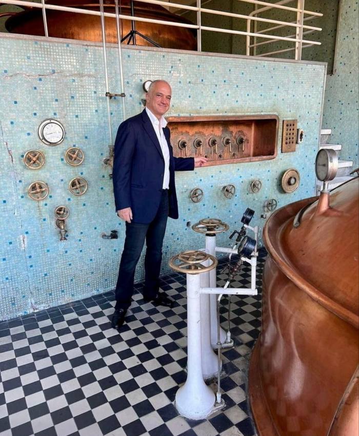 Philippe Jabre alongside a copper kettle and brewing equipment at Brasserie Almaza