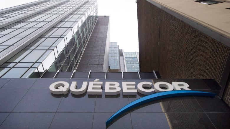 A company logo reading QUEBECOR is affixed to a building.