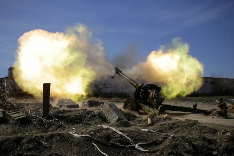 Ukrainian fighters are seen firing a howitzer toward Russian positions in Ukraine's Zaporizhzhia region in late March 2022.