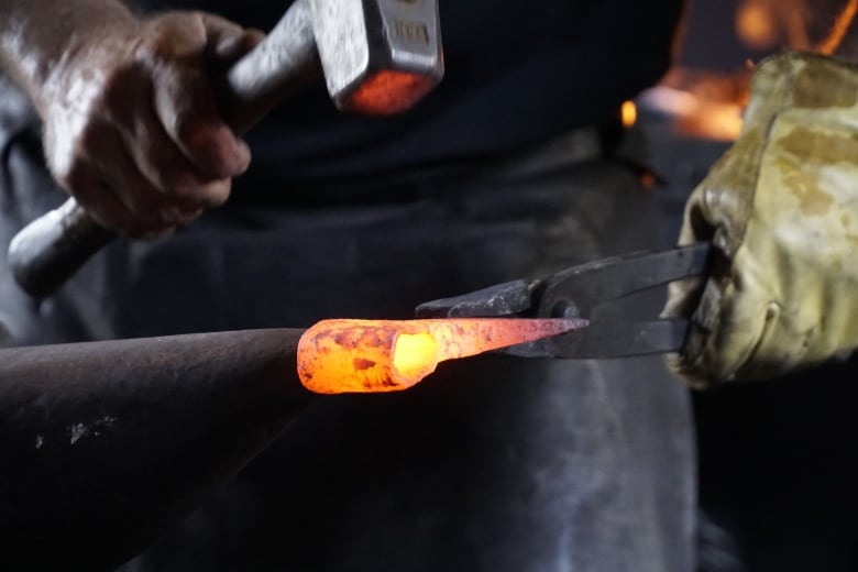 man working on anvil