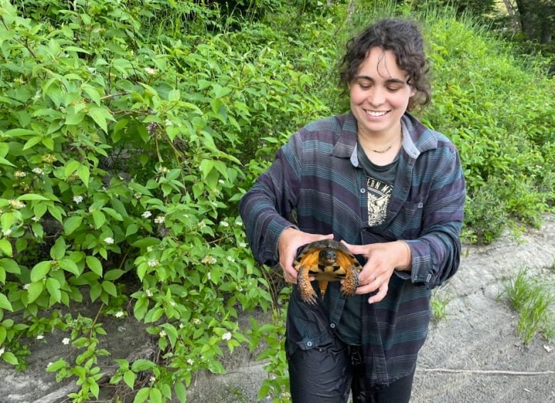 Woman holds turtle. 