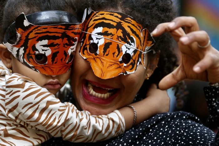 People wearing tiger masks in Bengaluru, India