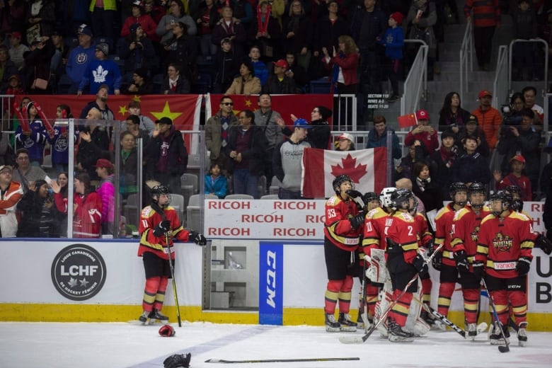 Hockey players stand by the bench.