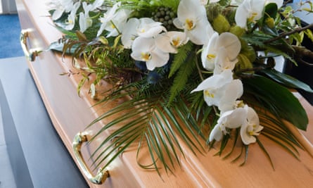 A coffin with a flower arrangement in a morgue