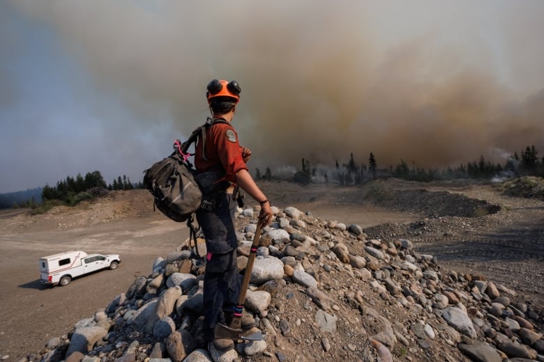 A firefighter with the British Columbia Wildfire Service keeps a look out at the head of the Tsah Creek wildfire burning near highway 27 outside Vanderhoof in northern British Columbia, Canada on July 11, 2023. 