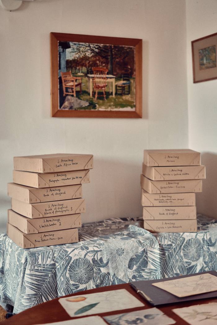 Boxes filled with drawings and photographs of Joseph Armitage’s work between 1910 and 1940, in front of an oil painting by Marthe